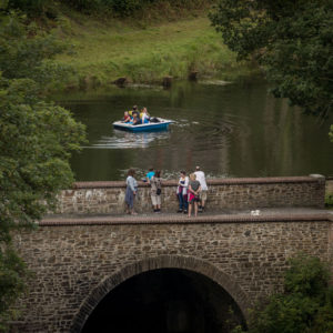 Bridge and Lake People on bridge and people in boat on lake