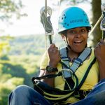 women on zipline smiling sunshine