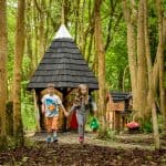 2 children in the elf and fariy village, holding hands walking